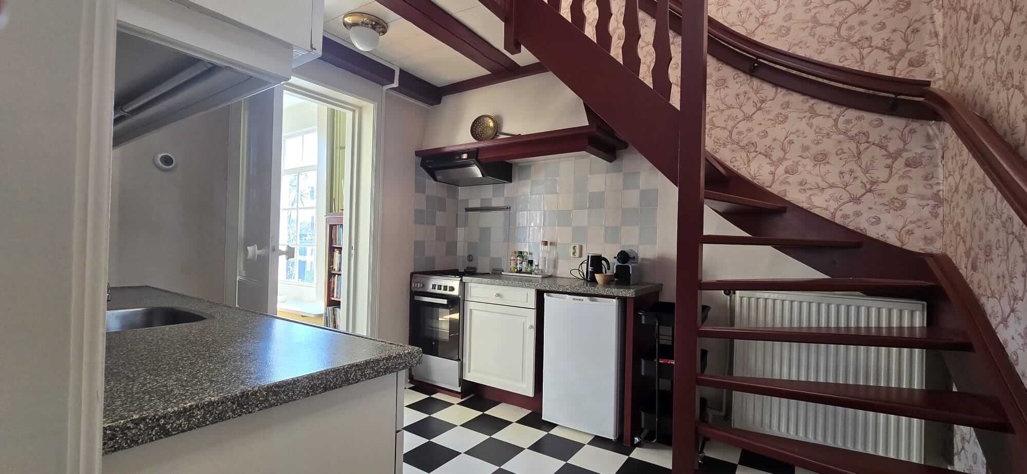 Authentieke keuken met houten trap naar de eerste verdieping