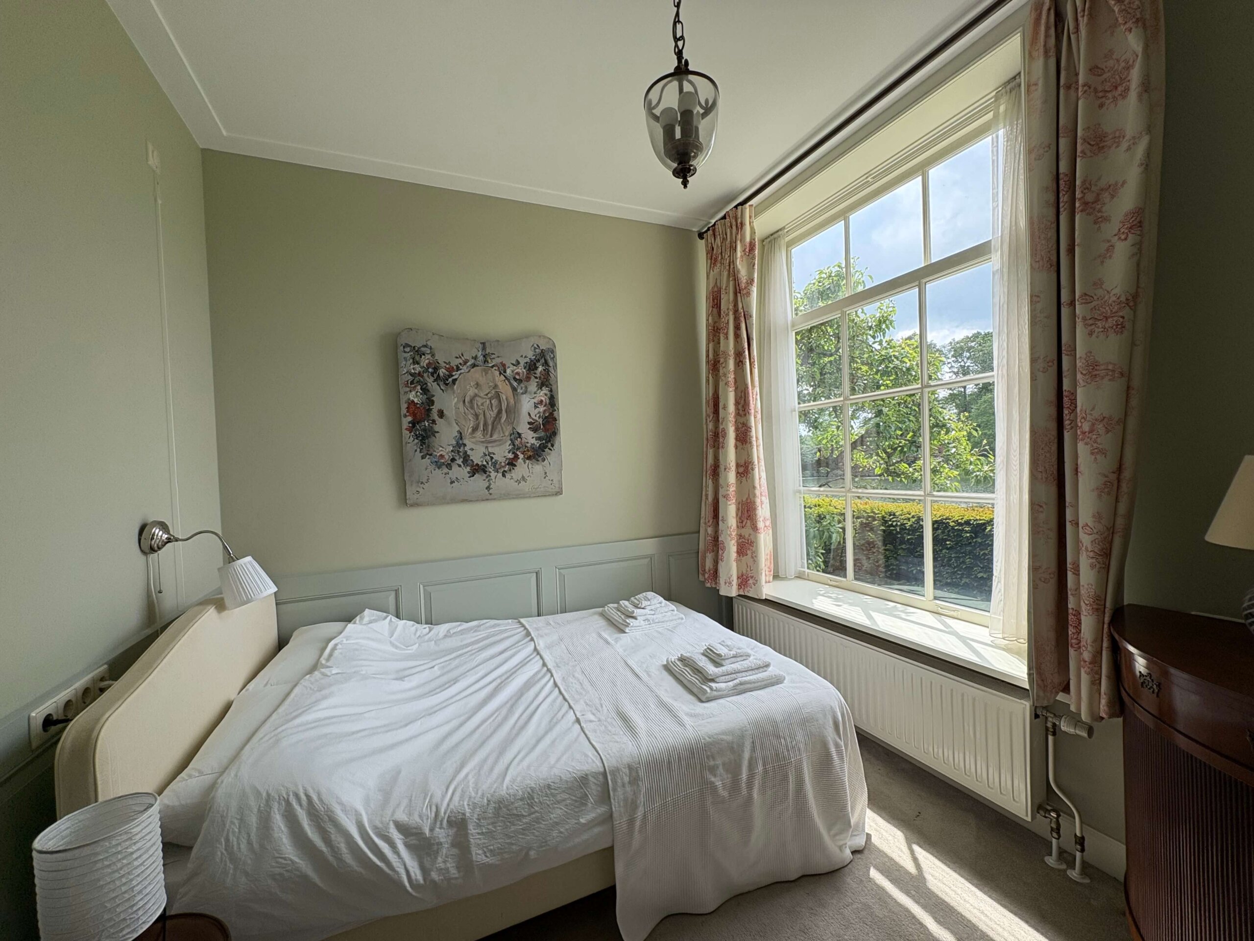 Lichte slaapkamer met tweepersoonsbed in het koetshuis